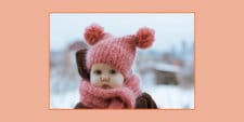 little girl wearing pink beanie and pink scarf in the snow- january baby names